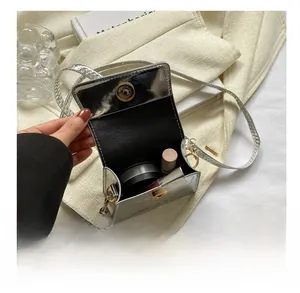 Detail view of mini silver croc-embossed handbag showing interior capacity for makeup