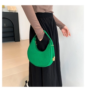 Side view of a green hobo shoulder bag in felt texture with golden hardware details