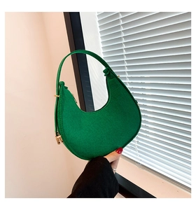 Close-up of green felt crescent shoulder bag with elegant gold hardware and matte finish