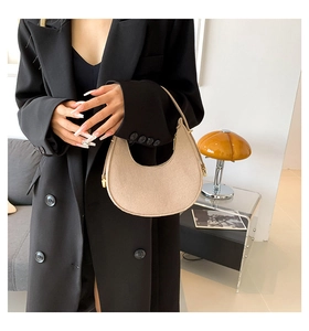 Close-up of beige felt half-moon shoulder bag with sleek zipper and gold hardware