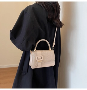 Détail du sac à main abricot avec texture pailletée, boucle carrée et bandoulière fine