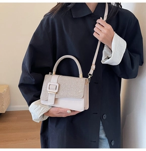 Détail d'un sac bandoulière crème avec rabat pailleté et finitions dorées chic