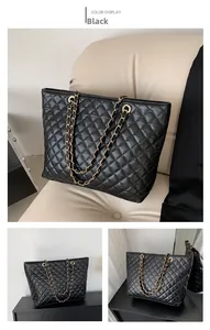 Detalle del bolso tote acolchado negro con cadena dorada y acabado de piel rugosa