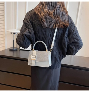 Détail du sac bandoulière à rabat pailleté avec boucle argentée et poignée