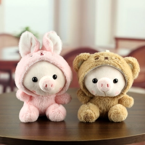 Mignons cochons en peluche avec sweats à capuche lapin et ours sur une table en bois