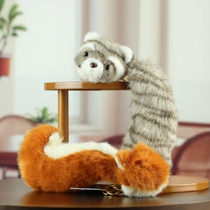 Plush red panda and raccoon stuffed animal keychain charms on wood tray