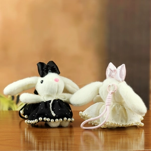 Detail of plush bunny charms with elegant lace dresses and pearl embellishments
