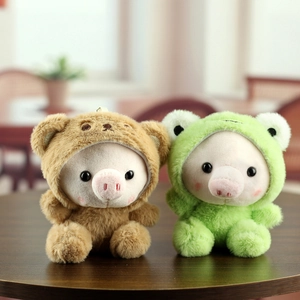 Poupées cochons en peluche déguisées en ours et grenouille sur une table en bois