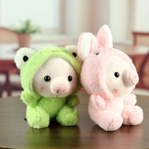 Détail de pendentifs cochons en peluche déguisés en grenouille et lapin pour sacs