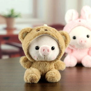 Détail d'un porte-clés cochon en peluche portant un sweat à capuche ours brun