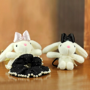 Detail showing plush rabbit hair accessories with pearl accents and silk bowknots