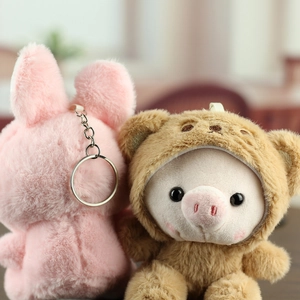 Détail du pendentif cochon en peluche avec capuche ours et lapin rose aux textures douces