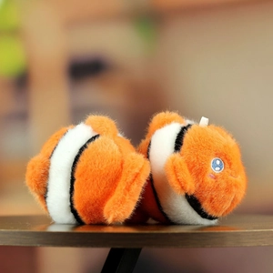 Detailed close-up of fluffy clownfish plush with orange stripes and soft embroidered blue eyes