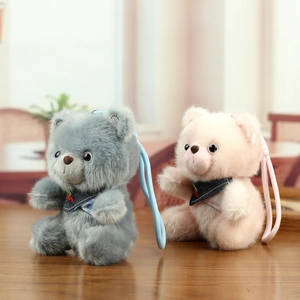 Cute plush bear charms in pink and grey with cherry bandanas on a wooden table