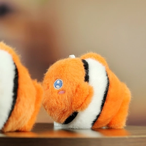 Macro close-up of orange clownfish plush keychain with detailed blue embroidery