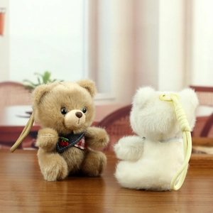 Close-up of cute plush bear charms with cherry bow ties on a dark wooden table