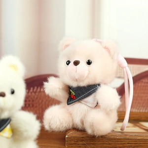 Detail of pink plush bear keychain with cherry scarf and soft woven strap