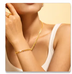 Detail eines 18k vergoldeten Schmucksets mit funkelnden Kristallen an Model und Hand