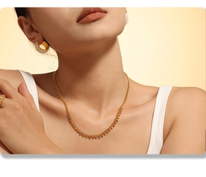 Gros plan d'un collier à pampilles en plaqué or 18 carats avec cristaux sur mannequin