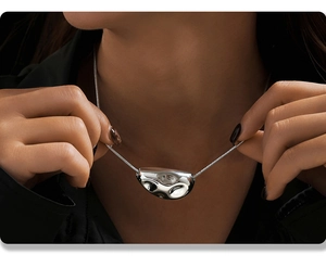 Macro shot of liquid metal organic pendant on silver snake chain worn by a model