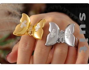 Close-up of gold and silver butterfly rings with sparkling rhinestones on hand