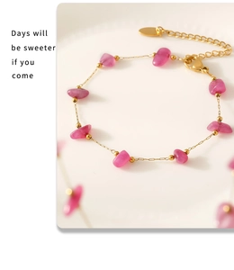 Macro detail of Bohemian gold chain bracelet with pink natural stones and lobster clasp