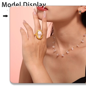 Detail of a fashion gold ring with large baroque pearl shown on a model's finger