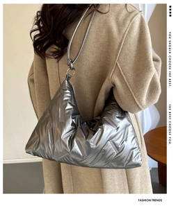 Close-up of a metallic silver padded shoulder bag featuring diagonal quilted patterns