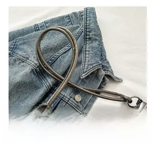 Detail of silver metallic puffer shoulder bag with chunky knotted tubular straps