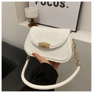 Détail du sac selle en cuir blanc montrant le fermoir doré et la bandoulière chaîne