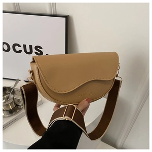 Détail du sac besace kaki avec large bandoulière tissée et finitions métalliques dorées