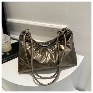 Detail of metallic bronze quilted tote with rope handle and knotted strap design