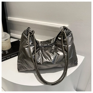 Detail of silver metallic quilted tote bag with puffy design and round shoulder straps