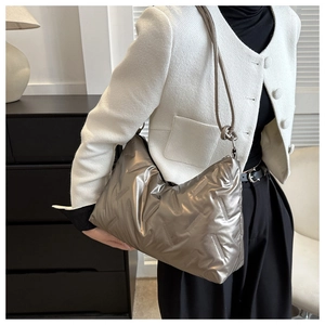 Close-up of a silver metallic quilted shoulder bag showing the texture and large capacity