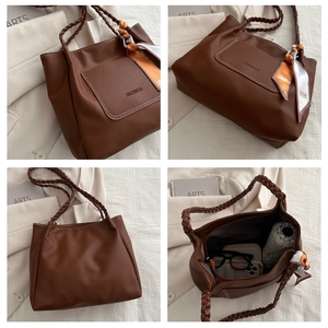 Détail d'un sac cabas marron en cuir grainé avec poignées tressées et foulard en soie