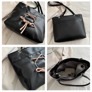 Vue détaillée du grand sac cabas noir avec ruban rose et intérieur spacieux pratique