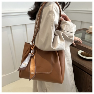 Sac fourre-tout marron avec bandoulière tressée et foulard en soie sur mannequin