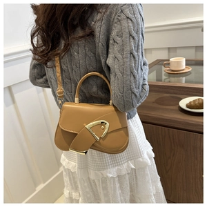 Side view of stylish brown saddle bag with large gold D-ring buckle on a model