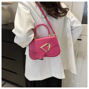 Hot pink leather shoulder bag featuring a prominent gold D-buckle shown on a white blazer