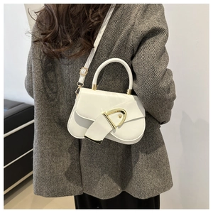 Close-up of a white saddle bag with a metallic D buckle and adjustable leather shoulder strap
