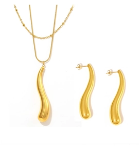 Gros plan détaillé sur l'ensemble collier double chaîne dorée et boucles d'oreilles gouttes