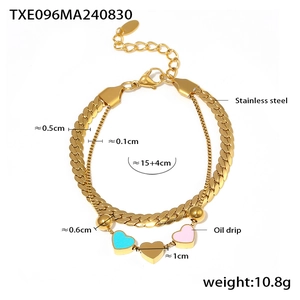 Détail macro du bracelet double couche en acier inoxydable doré avec charms cœur colorés