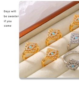 Detail of gold and silver Evil Eye square rings with turquoise and crystals in a box