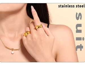 Detail of 18k gold plated stainless steel jewelry set with rings and pearl necklace