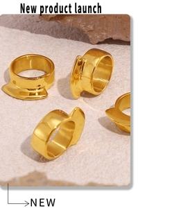 Macro shot of 18k gold plated chunky rings with wavy edges on stone background