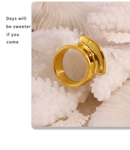 Macro shot of 18k gold plated geometric wave ring on coral texture display