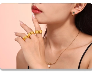 Dettaglio dell'anello a fiore placcato oro 18k e collana di perle su modella