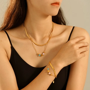 Parure collier double rang et bracelet dorés avec pendentifs cœurs colorés sur mannequin