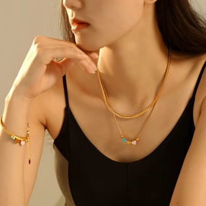 Collier double couche en acier doré avec cœurs en émail coloré sur mannequin asiatique