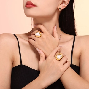 Baroque irregular pearl rings with golden wavy borders set on a model in warm light